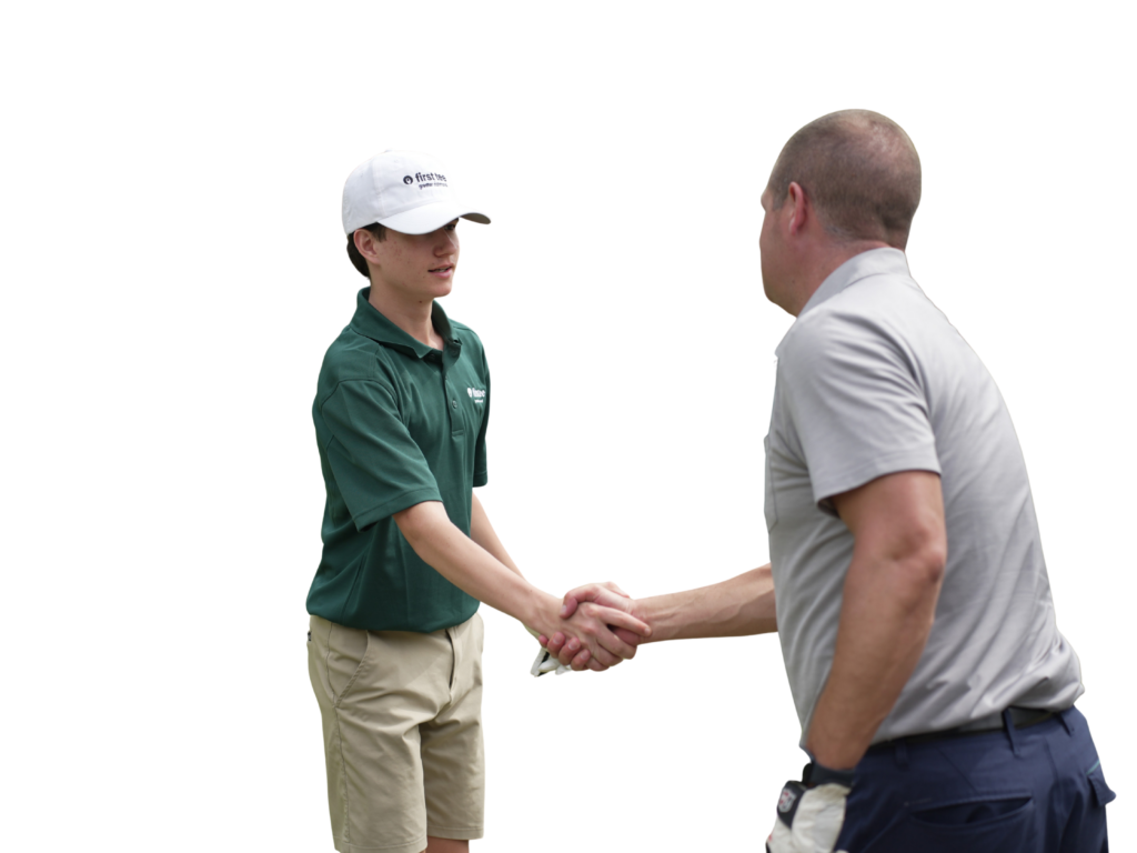First Tee participant shaking hands with an event attendee